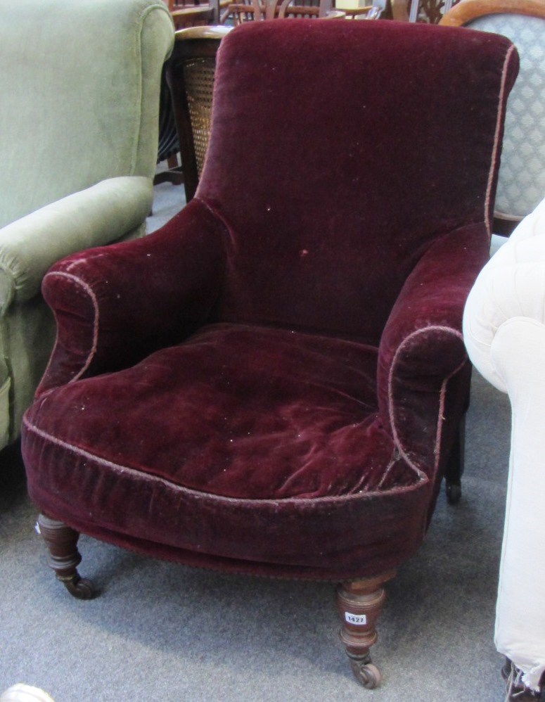 Appraisal: A th century red velvet upholstered easy armchair on turned