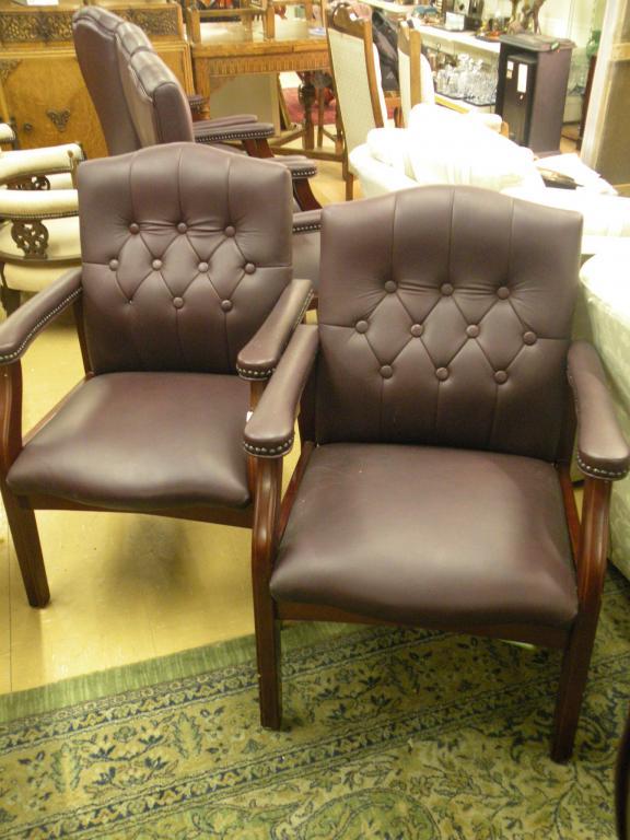 Appraisal: A pair of burgundy leather upholstered open armchairs