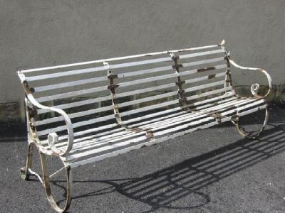 Appraisal: A WROUGHT IRON SLATTED GARDEN SEAT with scrolled back and