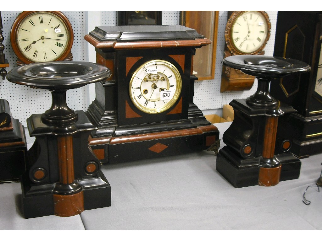 Appraisal: Black slate and brown marble two train clock garniture the