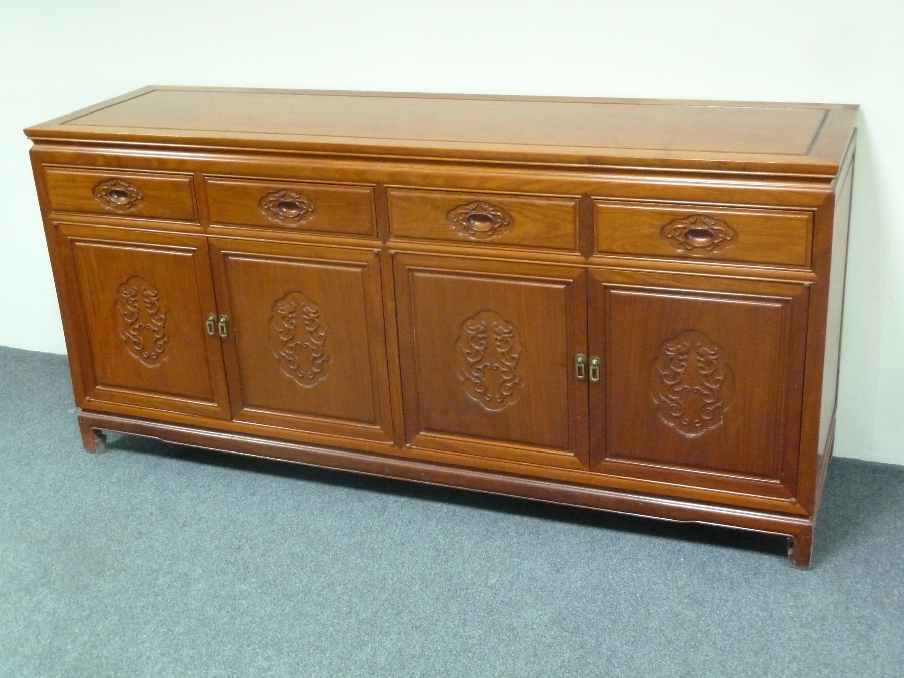 Appraisal: A Chinese hardwood sideboard fitted four drawers above two cupboards