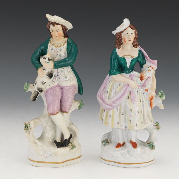 Appraisal: TWO STAFFORDSHIRE FIGURES OF MAN AND WOMAN WITH DOGS One