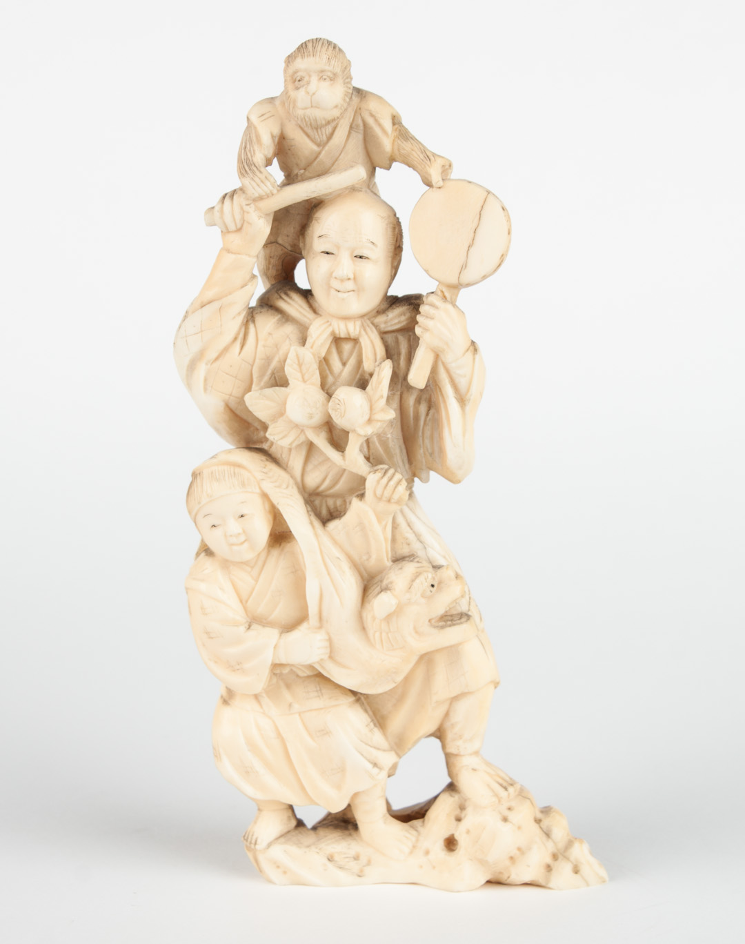 Appraisal: Japanese carved ivory celebration group modeled as man striking gong