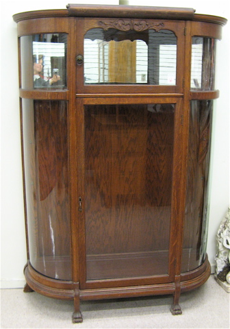 Appraisal: AN OAK AND CURVED GLASS CHINA DISPLAY CABINET American c