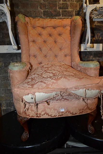 Appraisal: AN EARLY TH CENTURY WINGBACK ARMCHAIR IN DISTRESSED UPHOLSTERY