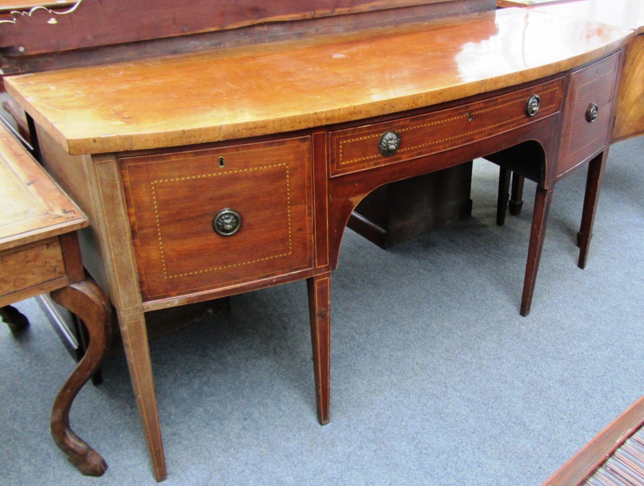 Appraisal: A George III inlaid mahogany bowfront sideboard on tapering square