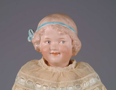 Appraisal: HEUBACH COQUETTE This grinning side-glancing child with a molded ribbon