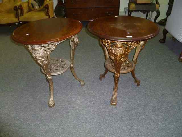 Appraisal: TWO VICTORIAN CAST IRON PUB TABLES with pierced and relief