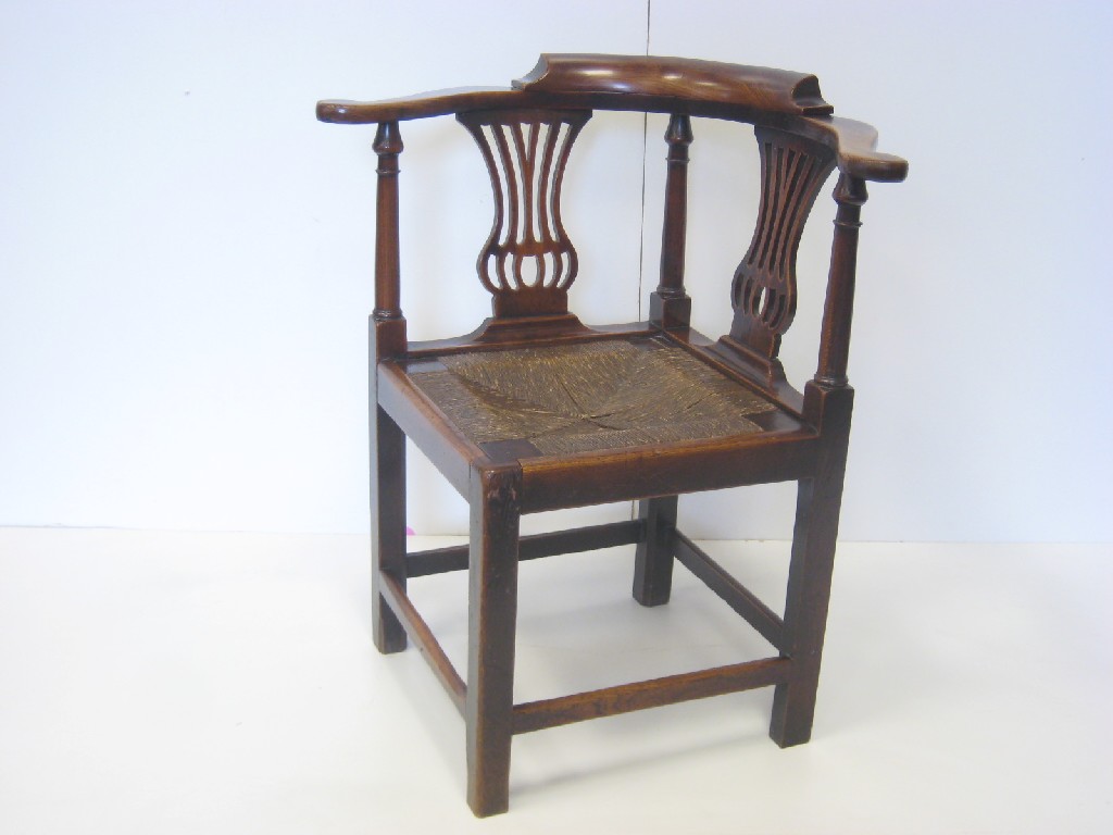 Appraisal: An antique elm Corner Armchair with pierced splats shaped arms