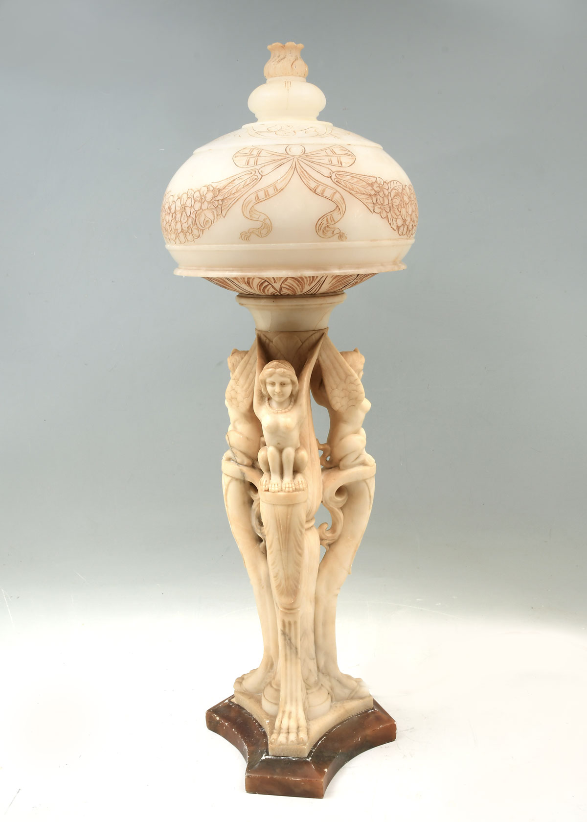 Appraisal: CARVED ALABASTER FIGURAL LAMP Leaf form body with female griffins