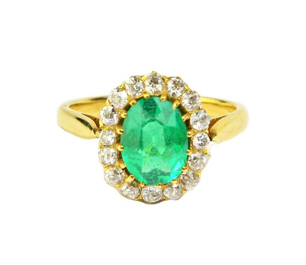 Appraisal: A gold emerald and diamond set oval cluster ring claw