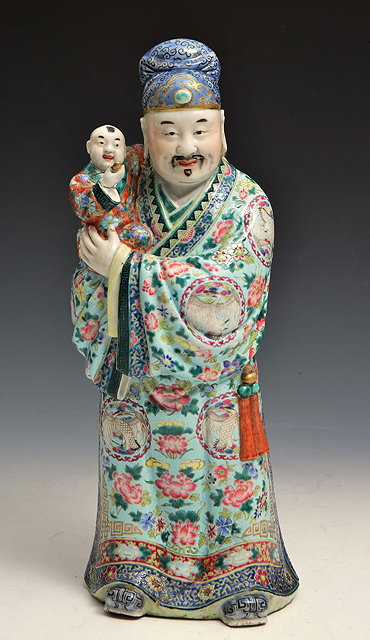 Appraisal: A CHINESE PORCELAIN FIGURE OF WU TI'S COURTIER carrying Wu-Ti's