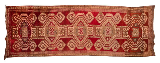 Appraisal: A CAUCASIAN RED GROUND CORRIDOR RUNNER with interlinked central medallion