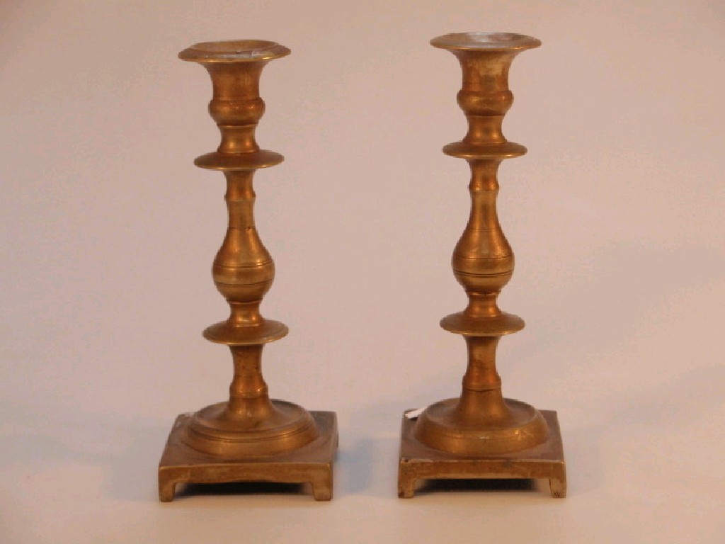 Appraisal: A pair of late thC cast brass candlesticks of knopped