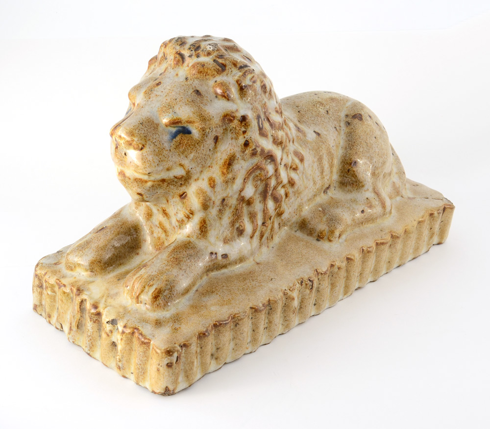 Appraisal: FOLK ART SEWER TILE RECLINING LION Mottled tan glaze with