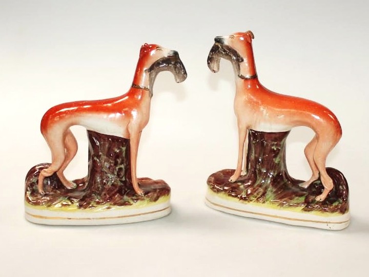 Appraisal: A pair of thC Staffordshire pottery greyhound figures each holding