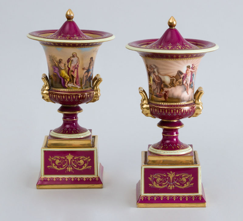 Appraisal: PAIR OF VIENNA PORCELAIN PICTORIAL CAMPANI-FORM URNS AND COVERS The