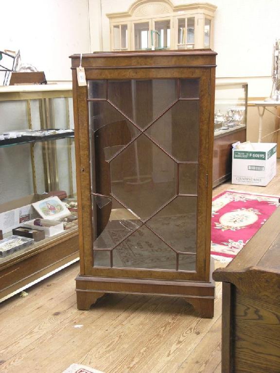 Appraisal: A reproduction burr walnut veneered display cabinet enclosed by single