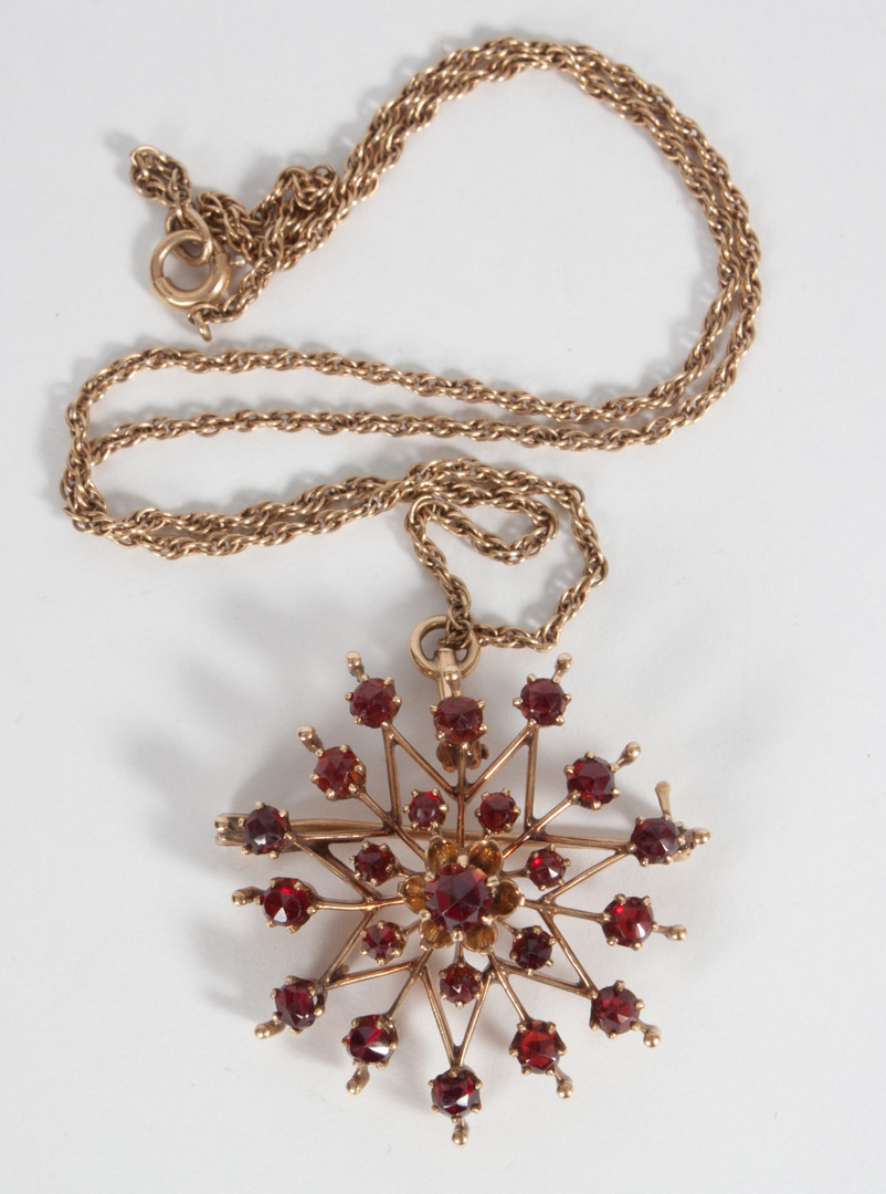 Appraisal: Garnet and gold snowflake pendant brooch in W unmarked gold