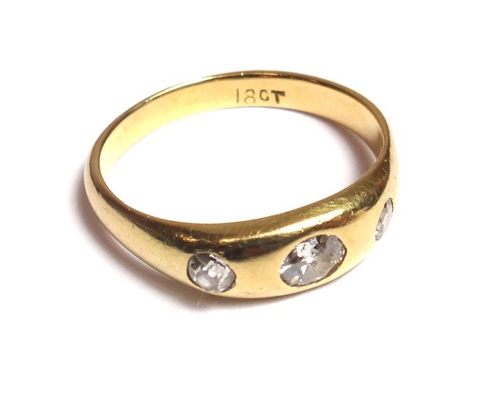 Appraisal: A gold and diamond set three stone ring gypsy set