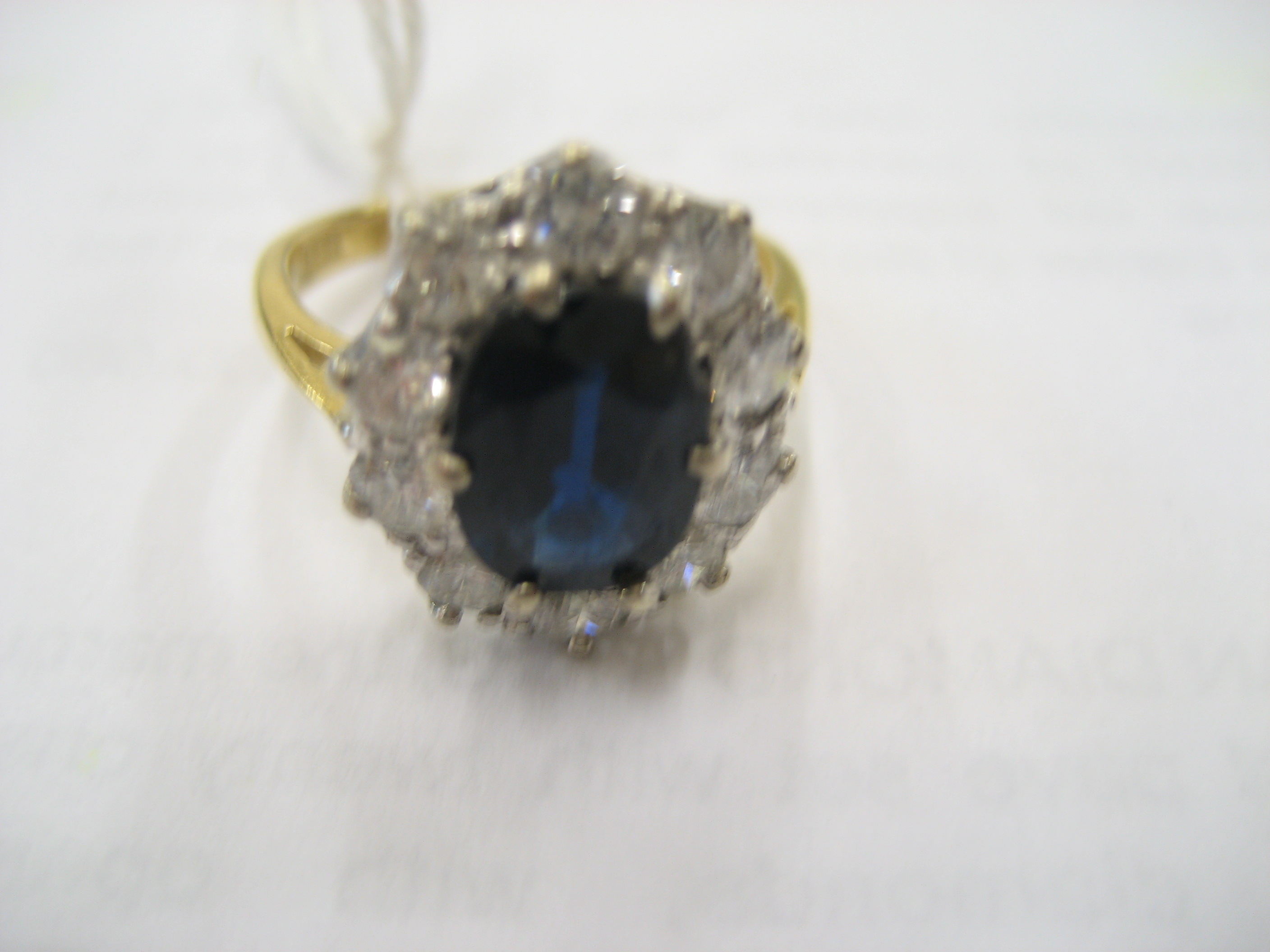 Appraisal: A SAPPHIRE AND DIAMOND CLUSTER RING the oval facet cut