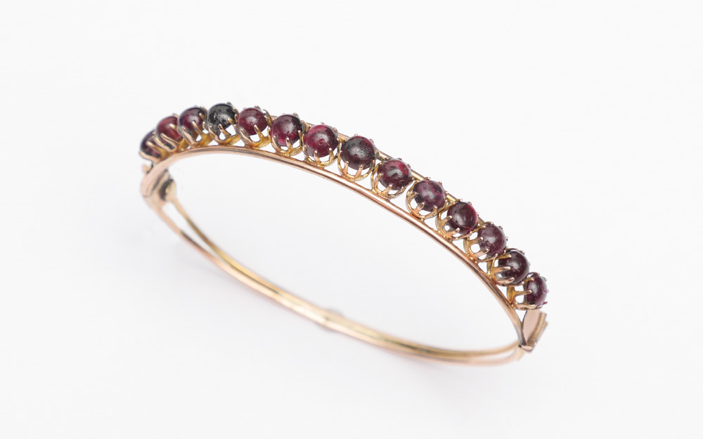 Appraisal: K BANGLE WITH CABOCHON GARNETS cabochon garnets are prong set