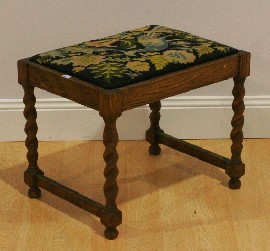 Appraisal: An oak and needlepoint upholstered stool with Jacobean twist legs