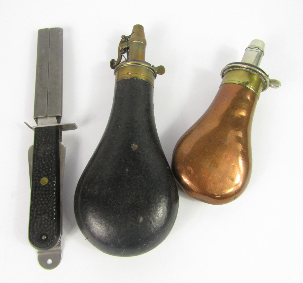 Appraisal: A black leather bound and brass powder flask copper and