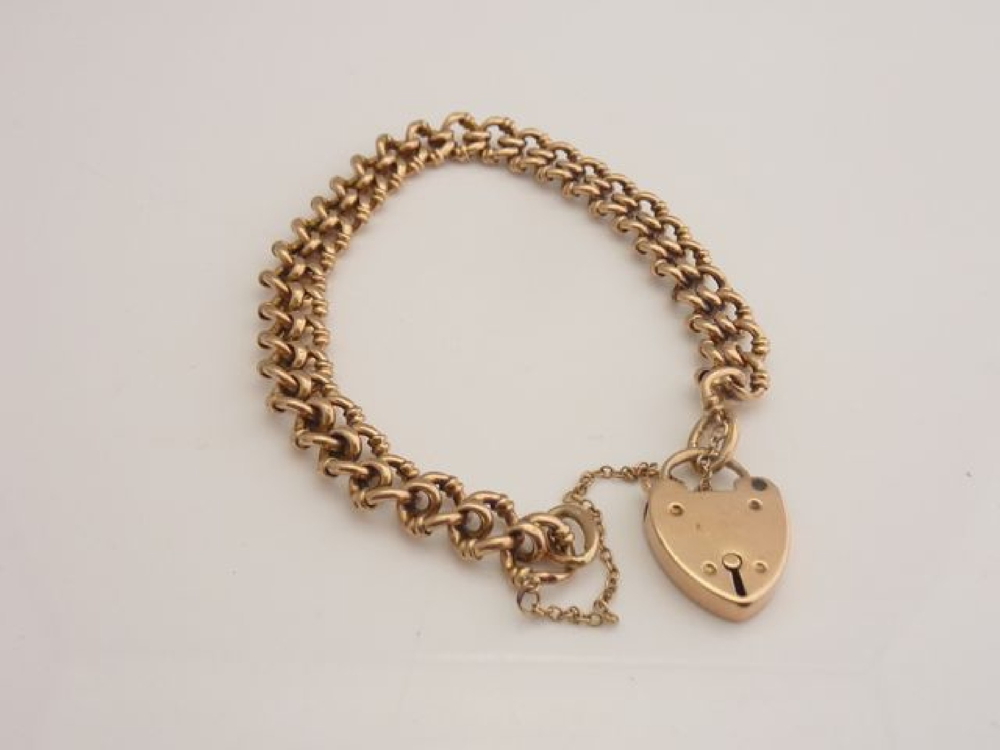 Appraisal: A ct rose gold fancy-link bracelet with heart-shaped padlock clasp