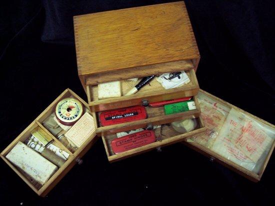 Appraisal: A small oak bank of four drawers containing angling equipment