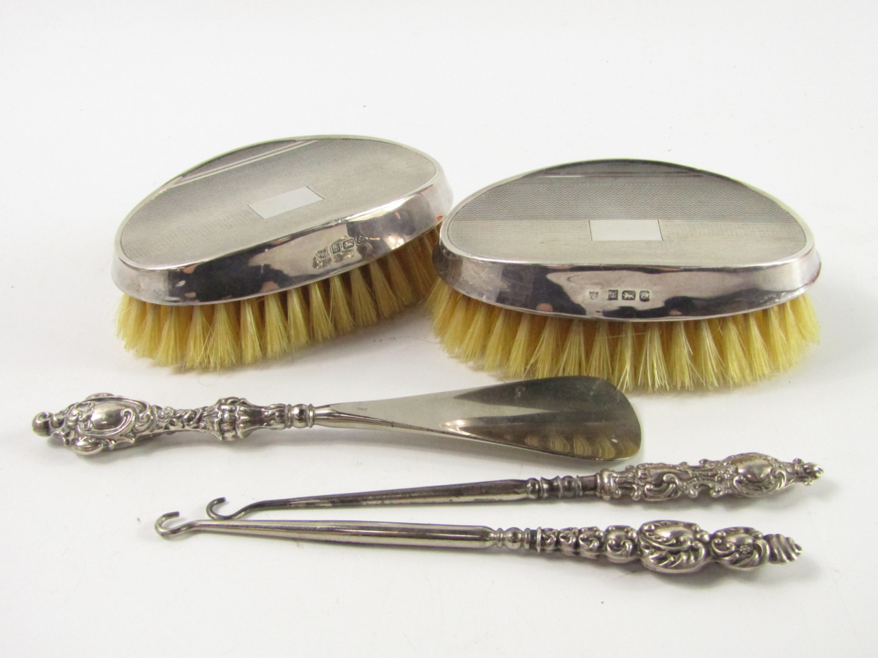 Appraisal: A pair of silver backed hair brushes with engine turned