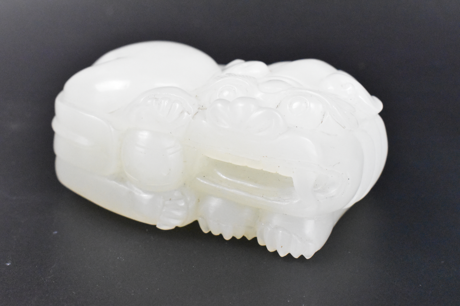 Appraisal: A Chinese jade carving of a foo lion Rectangular in