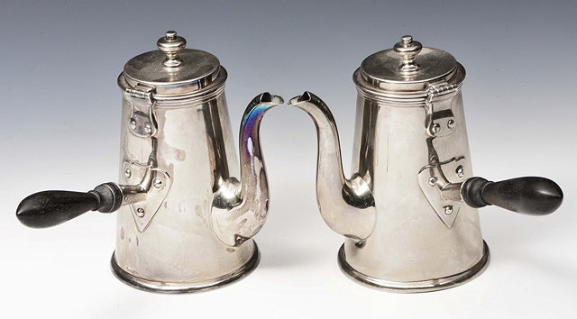 Appraisal: A PAIR OF SILVER SIDE HANDLED CHOCOLATE POTS with plain