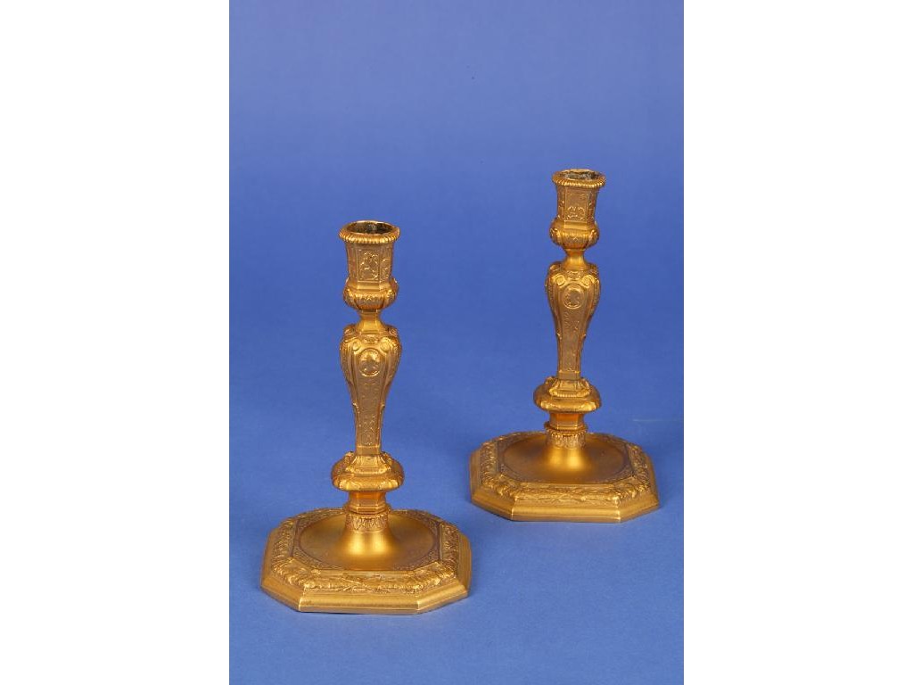 Appraisal: A PAIR OF REGENCE STYLE GILT METAL CANDLESTICKS with canted