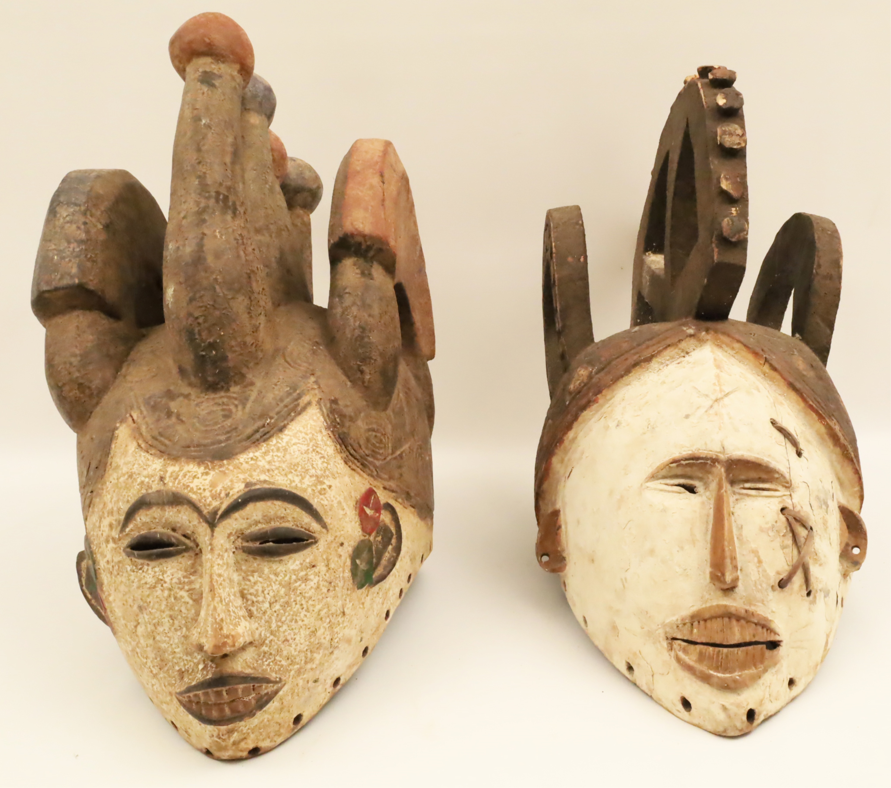 Appraisal: TWO AFRICAN TRIBAL MASKS Both carved wood with elborate three