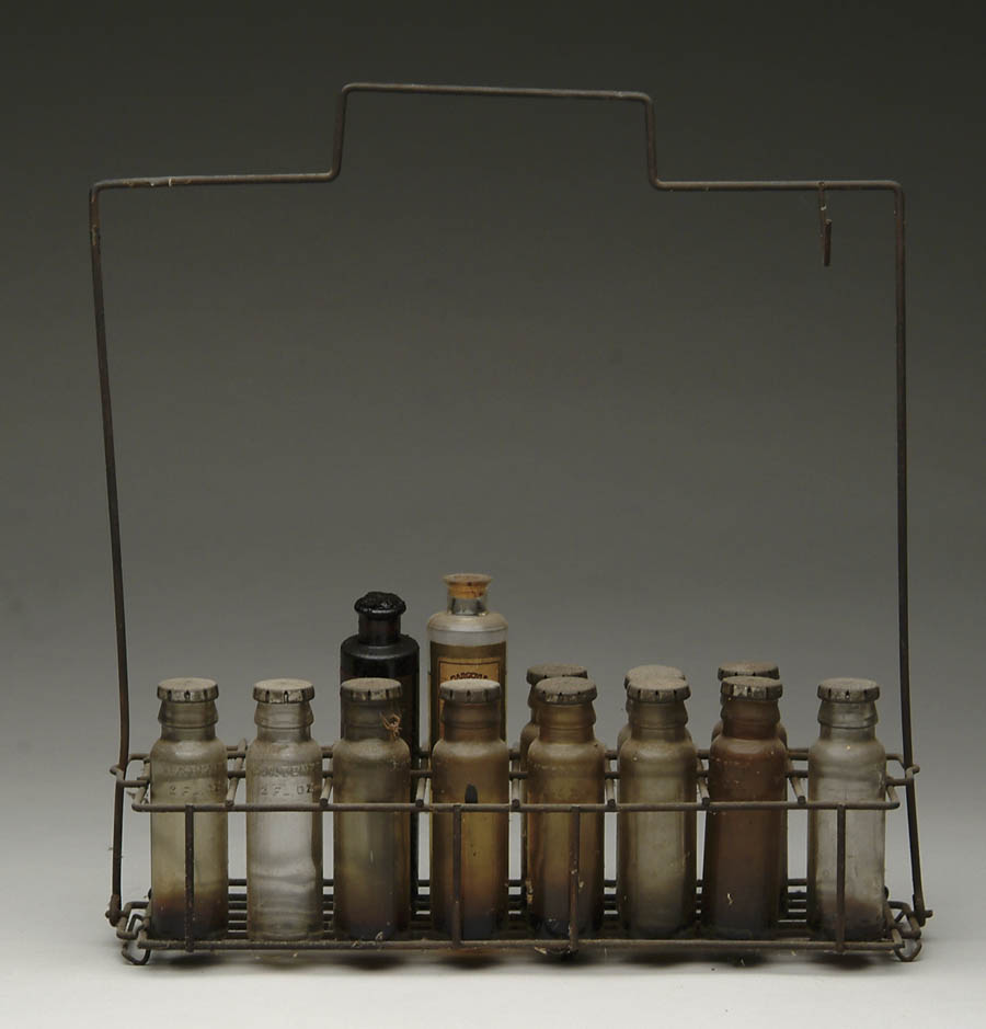 Appraisal: MOTOR OIL SAMPLE BOTTLES AND CARRIER Assortment of small glass