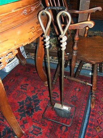 Appraisal: A pair of brass fire irons with coiled loop handles