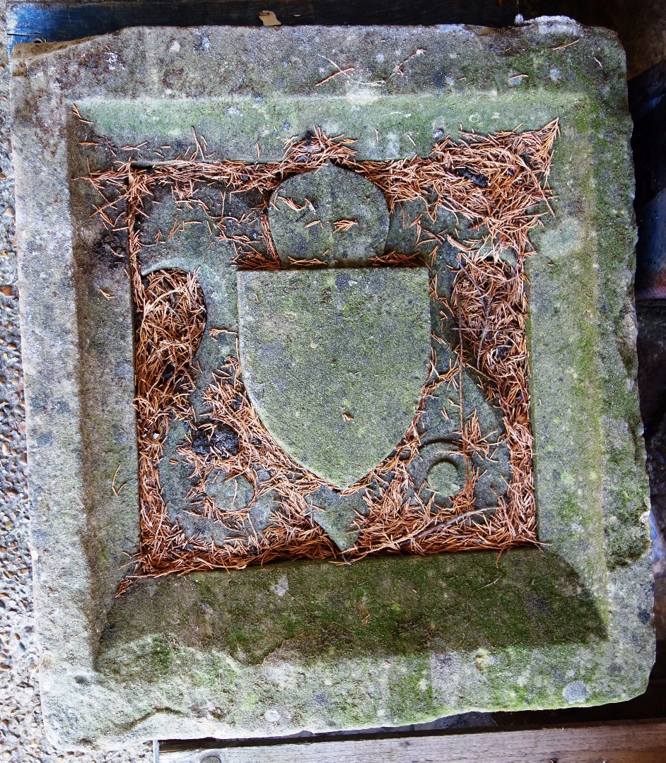 Appraisal: An th century carved stone square panel centred by shield