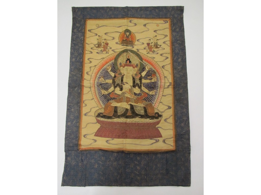 Appraisal: A Buddhist silk embroidered wall hanging Buddha enthroned acolytes above