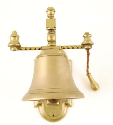 Appraisal: A bronze and brass bell on wall mounting bracket with