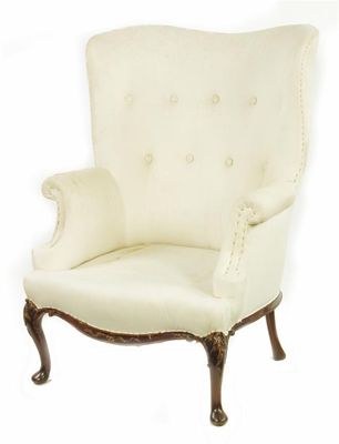 Appraisal: A wing armchair the shaped button back to scroll arms