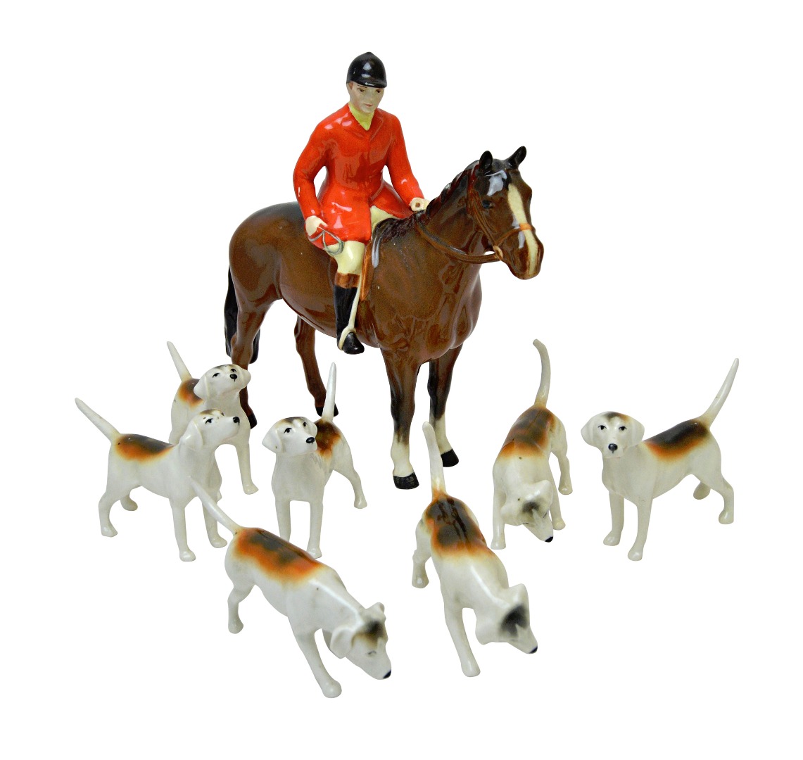 Appraisal: A Beswick huntsman on horseback and seven Beswick hounds black