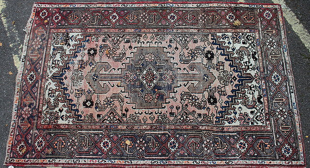 Appraisal: A PALE PINK GROUND MIDDLE EASTERN RUG the central lozenge