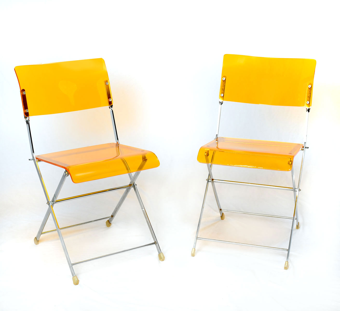 Appraisal: PAIR MODERN AMBER LUCITE FOLDING CHAIRS Mid-century modern folding chairs