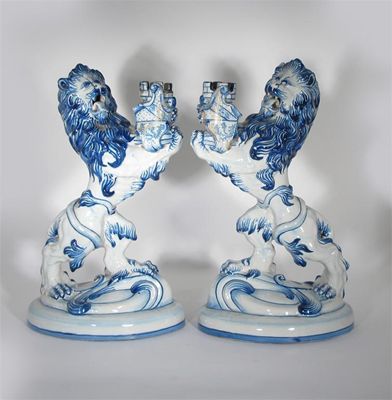 Appraisal: A pair Galle tin-glazed pottery heraldic candlesticks each modelled as