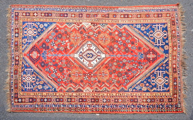 Appraisal: A KASHGAI RUST GROUND RUG with a central white ground