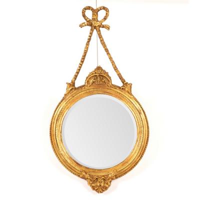 Appraisal: A circular gilt framed wall mirror suspended from a ribbon-tie