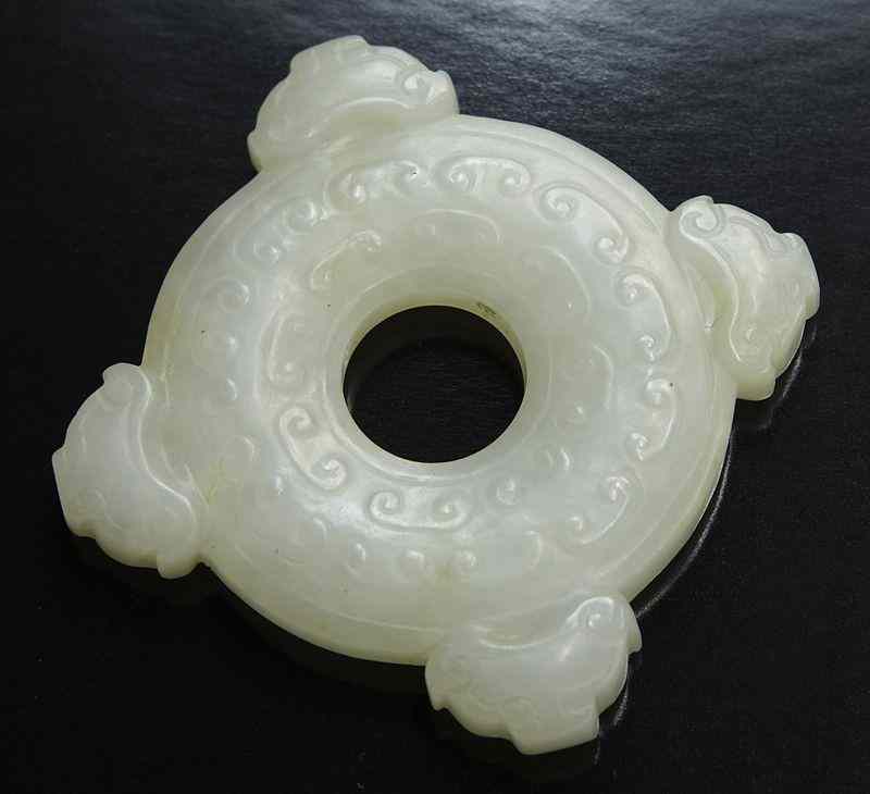 Appraisal: Chinese Qing carved jade bi-disk depicting scrolling clouds four chi-dragon