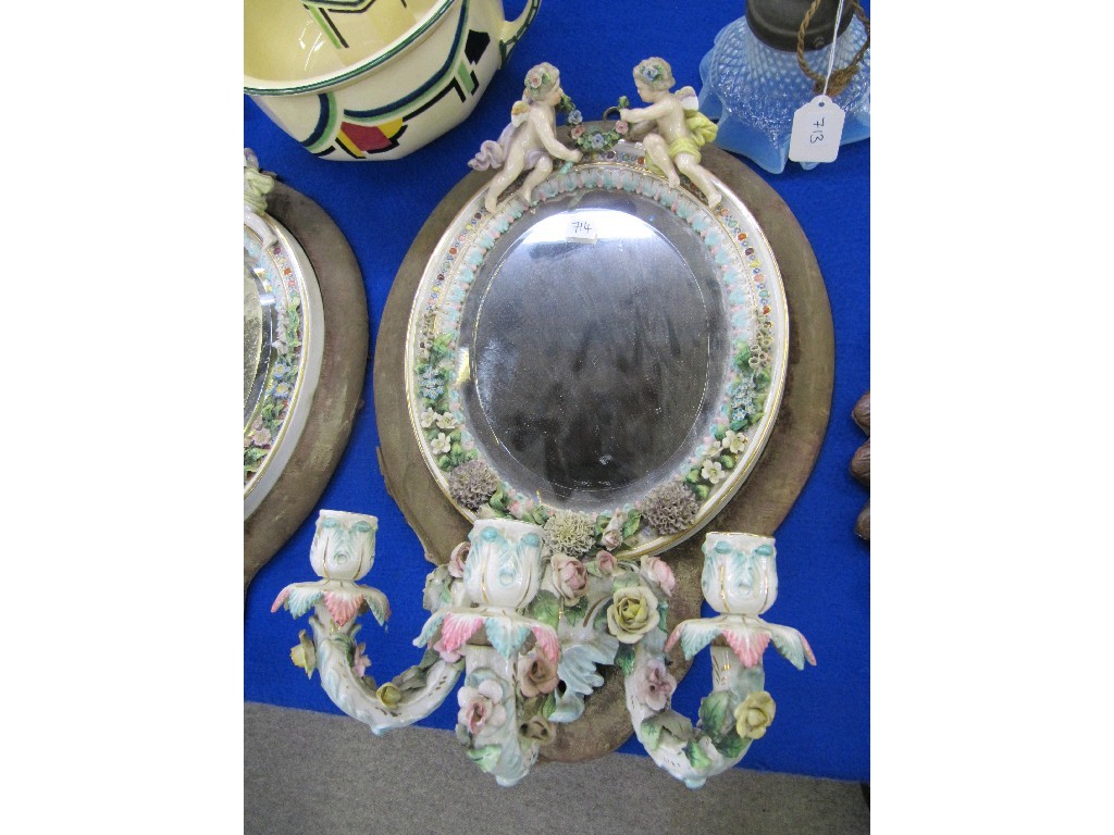 Appraisal: A pair of continental girandole wall mirrors decorated with cherubs