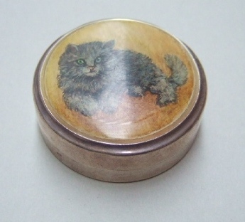 Appraisal: A circular silver box the detachable lid decorated with cat